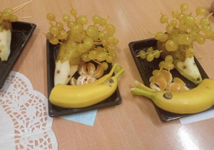 Na talerzykach zwierzątka z owoców: jeżyki z gruszki i winogrona oraz delfiny z bananów i winogron.