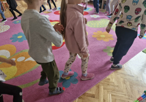 Dzieci w sali maszerują po kole.
