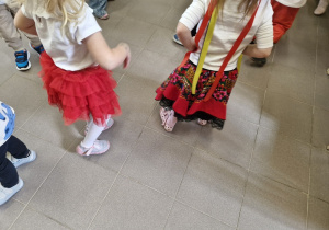Dziewczynki tańczą w narodowych i regionalnych strojach.