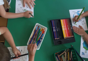 Dzieci oglądają kartę pracy na której widać co zanieczyszcza powietrze.