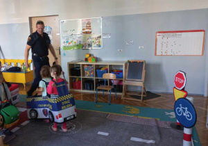 Dzieci w strojach pojazdów poruszają się po drodze.