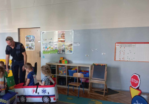 Dzieci w strojach pojazdów poruszają się po drodze.