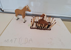 Zagroda dla konia z zapałek i plasteliny wykonana przez dziecko.