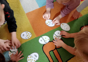 Dzieci układają puzzle - dopasowują kurczaczki do odpowiedniej liczby kropek.