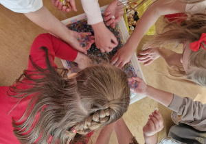 Dzieci wybierają guziki z pojemnika wypełnionego kulkami hydrożelowymi.