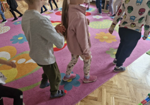 Dzieci w sali maszerują po kole.