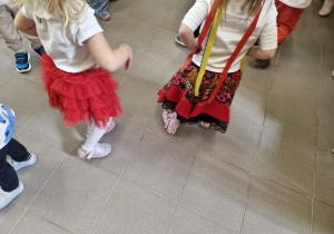 Dziewczynki tańczą w narodowych i regionalnych strojach.