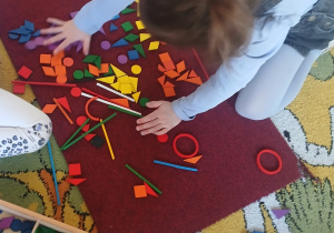 Dwie dziewczynki tworzą wspólną konstrukcję z darów Froebla – układają figury geometryczne w słońce oraz różnorodne elementy krajobrazu afrykańskiego.