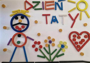 Obrazek ułożony z darów zabawy Froebla: mężczyzna, kwiaty, słońce, serduszko, napis dzień taty
