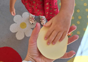 Dziewczynka daje nauczycielowi znalezioną w sali kropkę.