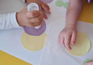 Dzieci tworzą rożne kompozycję z papierowych kropek.