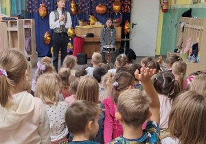 Dzieci siedzą na ławeczkach podczas audycji muzycznej z Bachmanem.