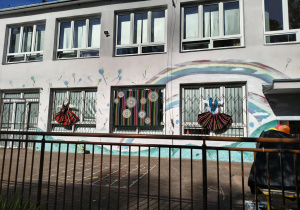 Na kratach okien wywieszone stroje ludowe.