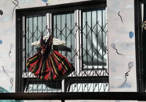 Strój ludowy wywieszony na oknie.