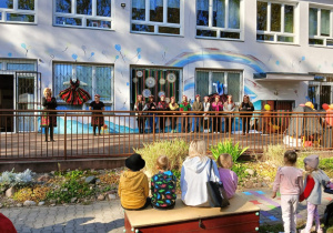 Dyrekcja i nauczyciele w strojach ludowych na tarasie przedszkolnym.