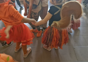 Dzieci tańczą w kółeczku podczas balu.