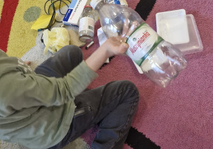 Chłopiec w ręce trzyma plastikową butelkę.