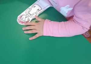 Dziewczynka koloruje postać - wykonuje pacynkę.