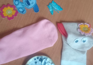 Na stoliku elementy, z których dzieci wykonają pacynki - skarpetki, ruchome oczka, naprasowanki.