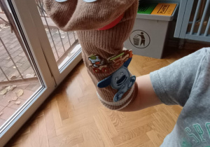 Dziecko prezentuje wykonaną przez siebie pacynkę ze skarpetki.