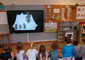 Dzieci oglądają przedstawienie cieni na tablicy multimedialnej.