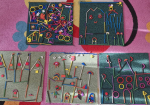 Na dywanikach ułożone zamki z darów zabawy Froebla.
