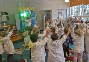 Dzieci łapią sztuczny śnieg.