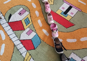 Dzieci układają swoje buty jeden za drugim.