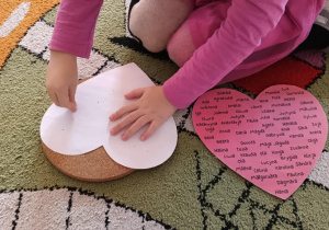 Dziewczynka przebija pinezką serce.