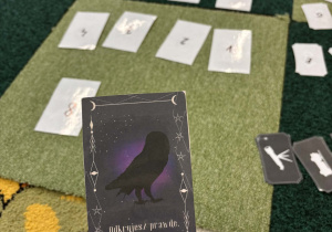 Nauczyciel trzyma w ręce kartę z wróżbą.