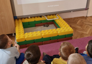 Dzieci na tablicy multimedialnej oglądają film o prawach dziecka.