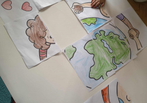 Dzieci wykonują wspólną pracę plastyczną związaną z prawami dziecka.