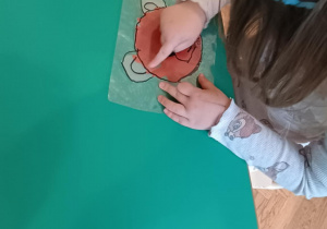 Dziecko przy stoliku wykonuje pracę - misia.