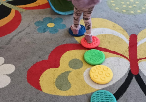 Dziewczynka pokonuje tor przeszkód ze swoim misiem.