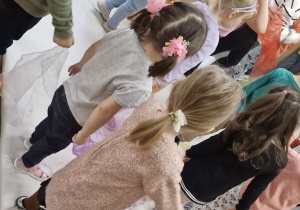 Dzieci stoją na materacu. W rączkach trzymają tiulowe chustki.