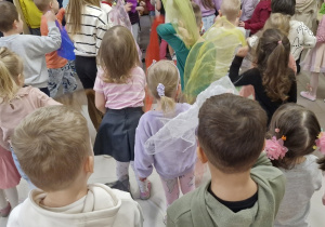 Dzieci machają chustkami w rytm muzyki.