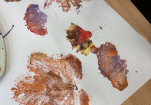 Kolorowe odbite liście na kartce.