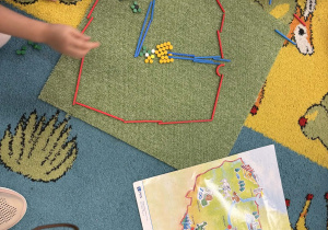 Dzieci układają mapę Polski z darów zabawy Froebla.