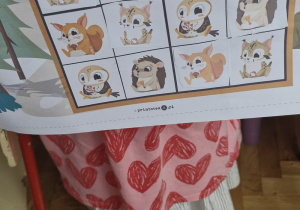 Dziewczynka prezentuje swoją pracę - sudoku ze zwierzętami.