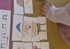 Dziecko układa Mikołaja z pociętych części.