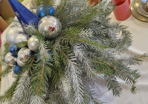 Na wigilijnym stole stroik świąteczny.