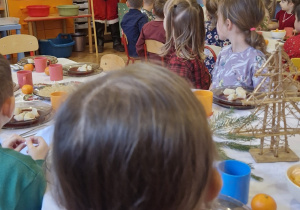 Dzieci obserwują Mikołaja wchodzącego do sali.