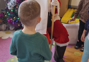 Chłopiec odbiera prezent od Świętego Mikołaja.