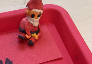 Wylepiony Mikołaj z plasteliny na czerwonej tacy.