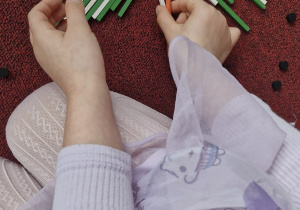 Dziecko układa choinkę z darów zabawy Froebla.