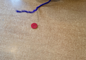 Dziecko nawleka guziki na druciki kreatywne.