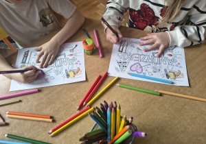 Dzieci kolorują plakaty andrzejkowe.