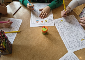 Dzieci rozwiązują labirynty świąteczne.