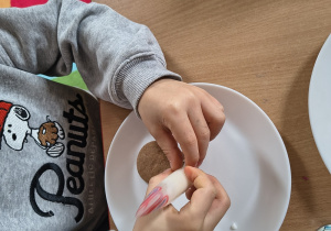 Chłopiec dekoruje swojego pierniczka.