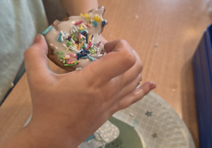 Dziecko prezentuje wykonanego przez siebie piernika.